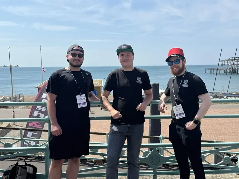 Three Shiverbug Studios team members on Brighton seafront in studio t-shirts